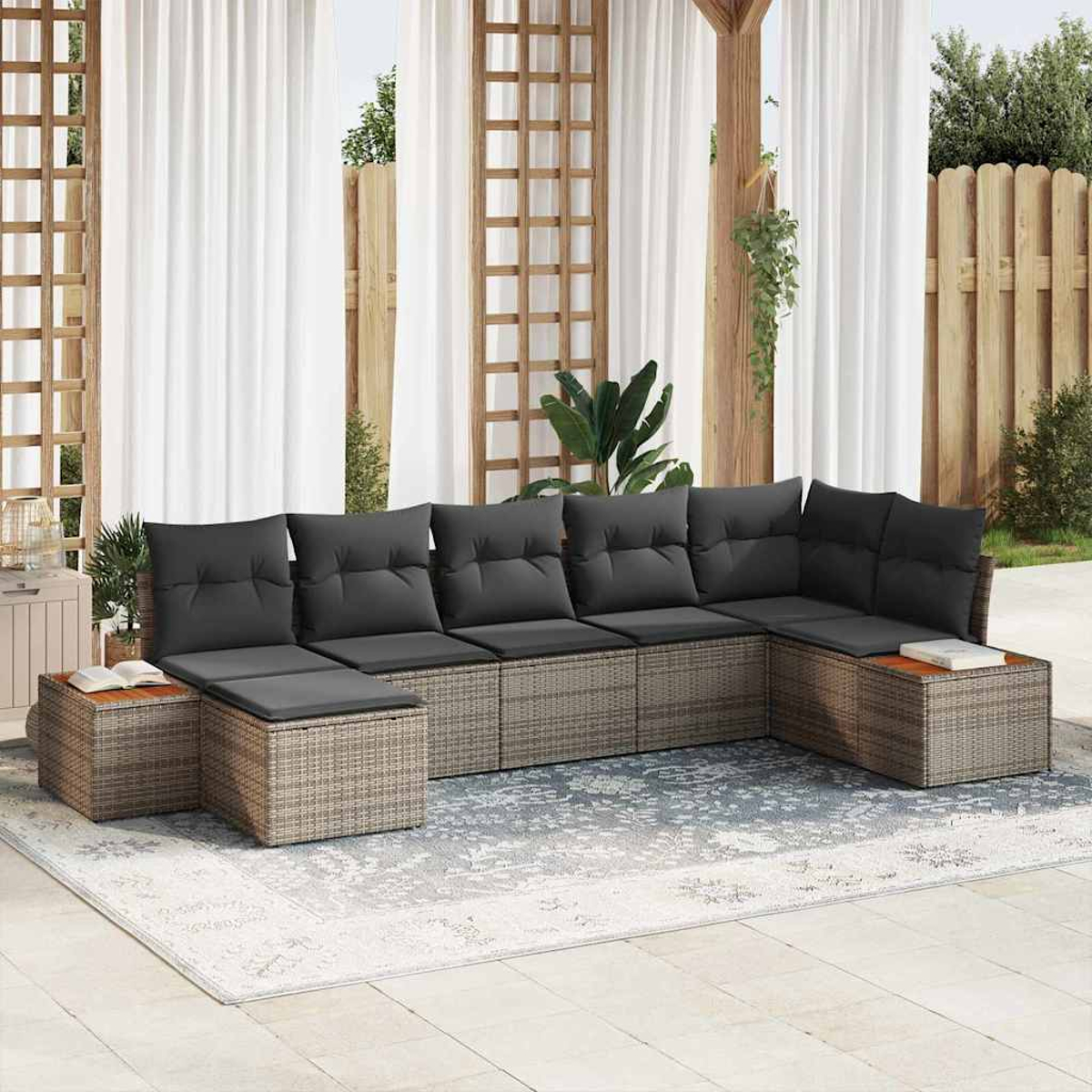 Outdoor-Ecksofa mit grauen Kissen auf einem gemusterten Teppich. Gardinen und Holzgitter im Hintergrund.