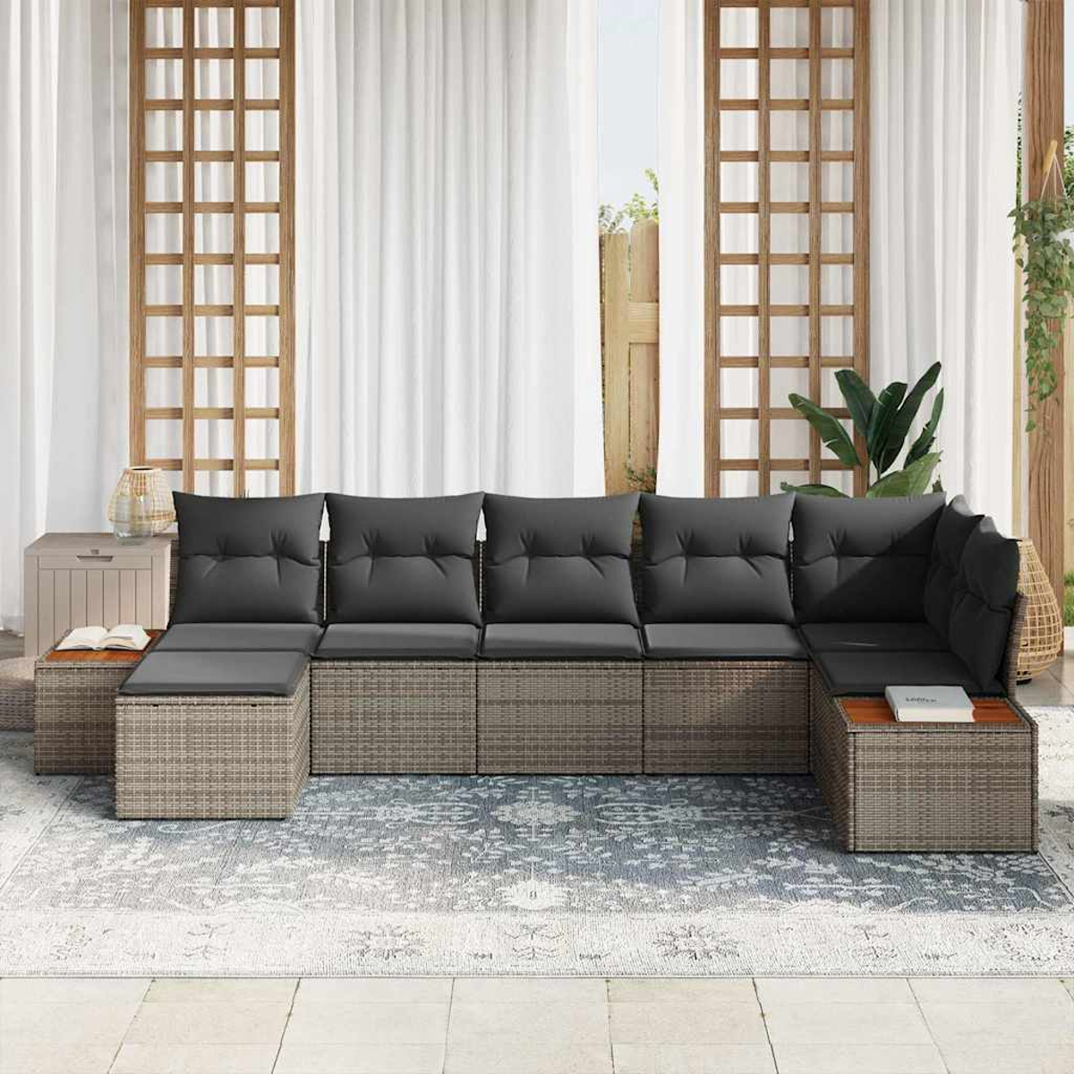 Outdoor-Ecksofa mit grauen Kissen. Es steht auf einem gemusterten Teppich, mit weißen Vorhängen und Holzgitter im Hintergrund.
