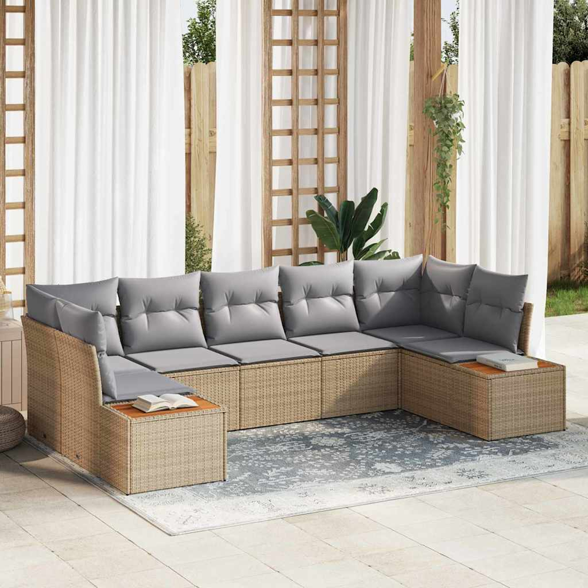 Geflochtenes Ecksofa mit grauen Kissen auf einem Teppich. Weiße Vorhänge und Holzgitter im Hintergrund, wodurch ein Außenbereich entsteht.