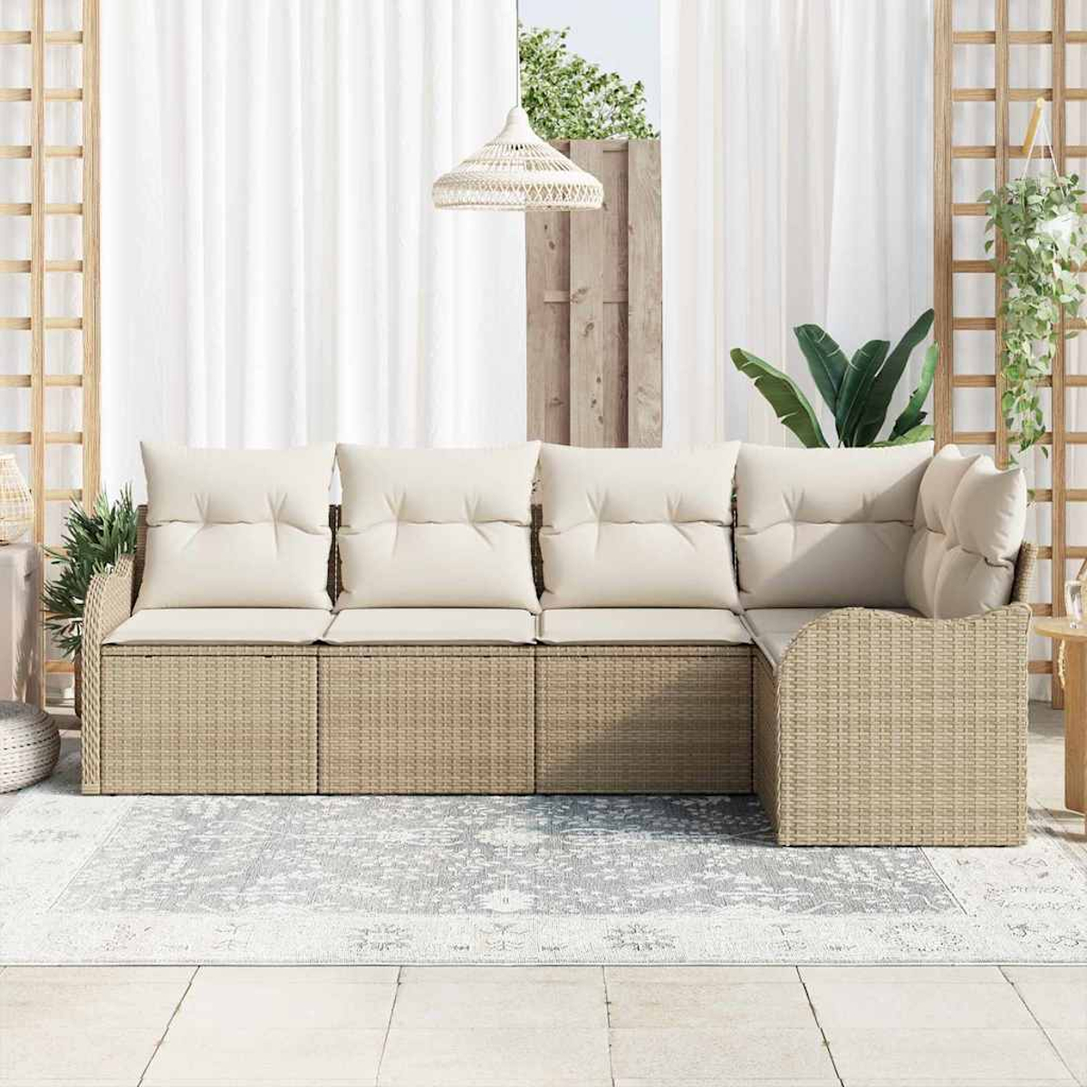 Geflochtenes Outdoor-Ecksofa mit cremefarbenen Kissen. Grauer gemusterter Teppich. Weiße Vorhänge und eine Hängeleuchte im Hintergrund.