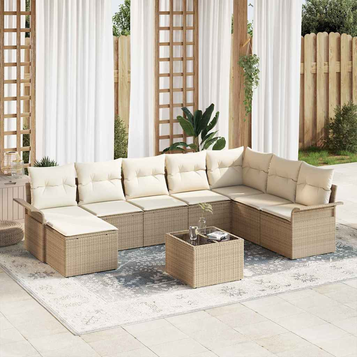 Geflochtenes Outdoor-Ecksofa mit cremefarbenen Kissen und quadratischem Korbtisch auf einem gemusterten Teppich.