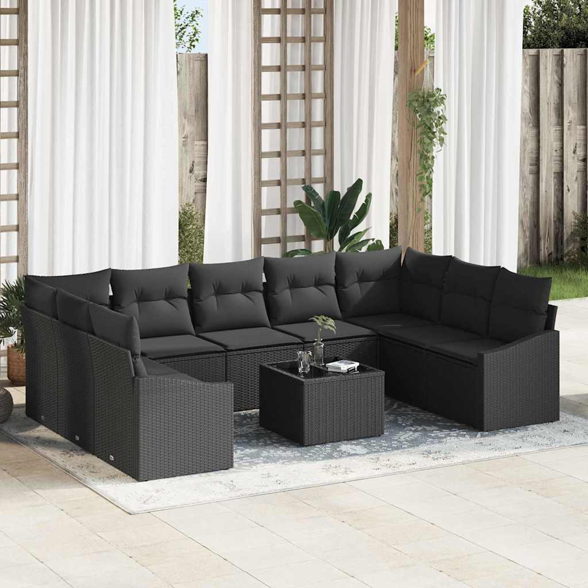 Outdoor-Ecksofa mit schwarzen Kissen, einem kleinen quadratischen Tisch und weißen Vorhängen im Hintergrund. Die Szene spielt auf einer Terrasse.