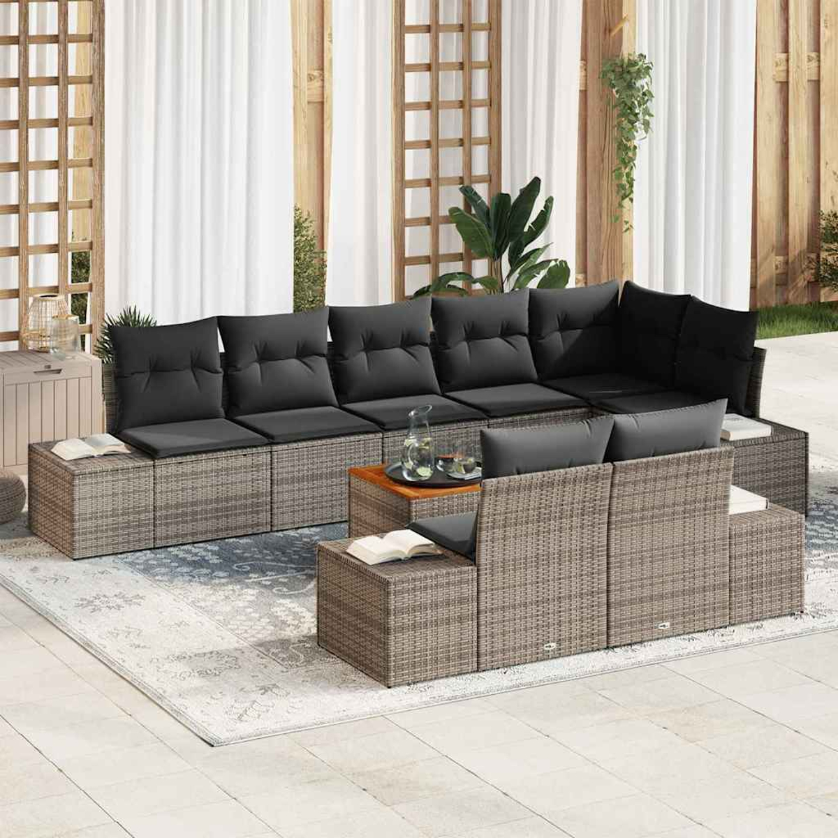 Outdoor-Ecksofa mit grauen Kissen. Ein Holztisch mit Gläsern und ein Buch auf einem würfelförmigen Sitz sind sichtbar.