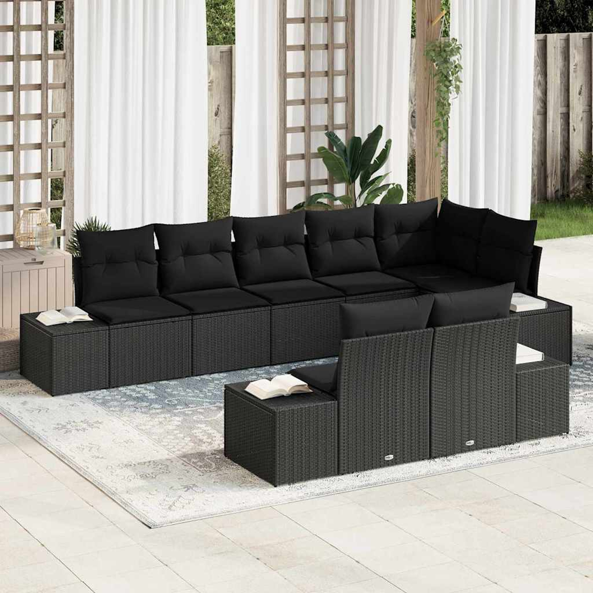 Outdoor-Ecksofa mit schwarzen Kissen. Bücher auf Beistelltischen. Weiße Vorhänge im Hintergrund. Terrasse mit Teppich.