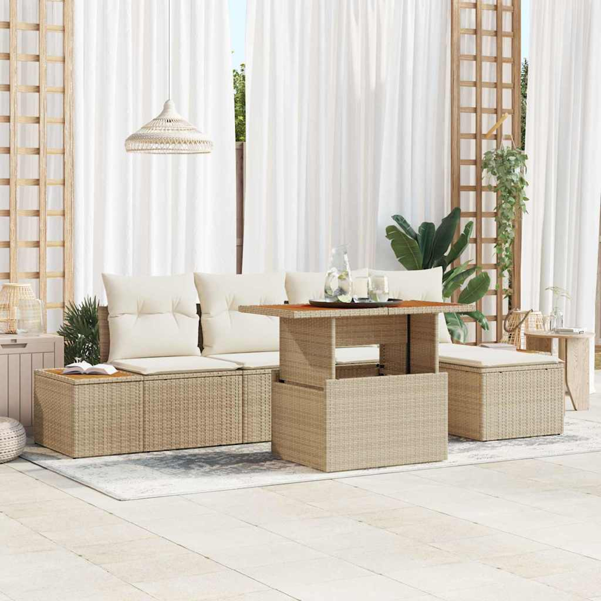 Gartenmöbel-Set aus Korbgeflecht mit weißen Kissen, Tisch und Vorhängen. Pflanzen und ein Teppich ergänzen die Szene.