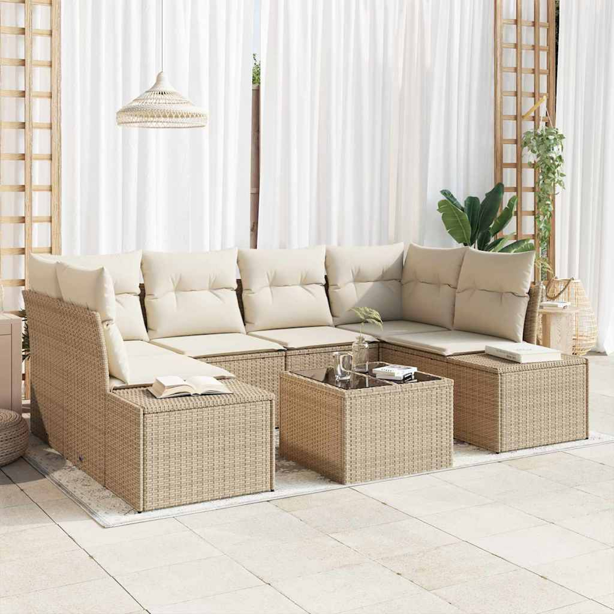 Sofá seccional de mimbre con cojines beige y una mesa de centro con tapa de cristal. Cortinas blancas y una lámpara colgante al fondo.