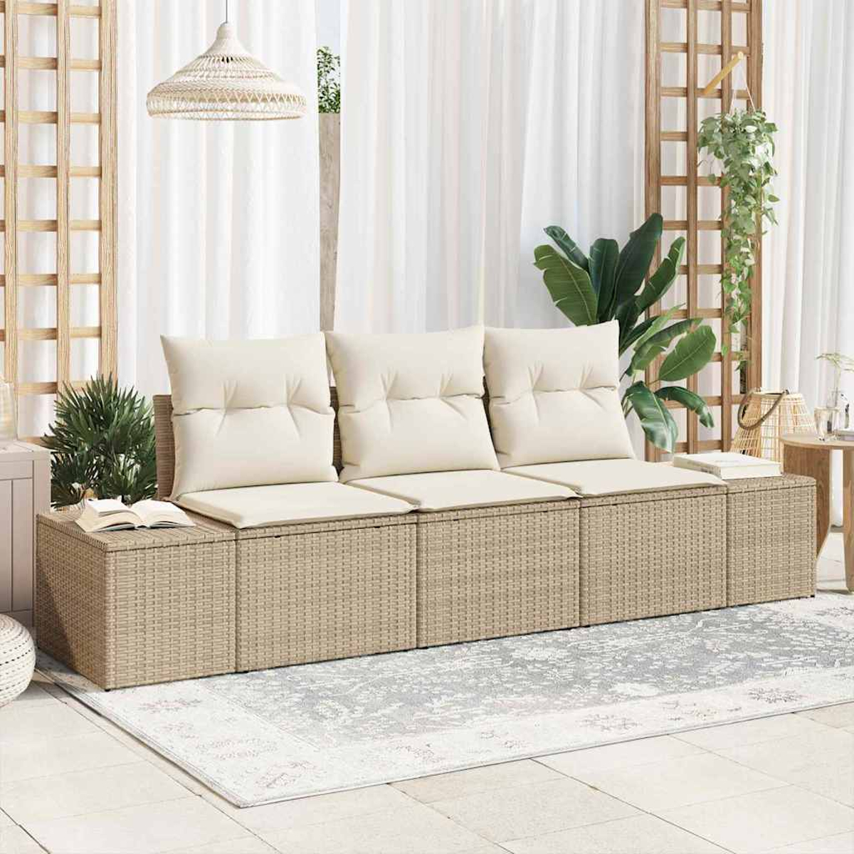 Ein beiges Rattansofa mit cremefarbenen Kissen steht auf einem Teppich. Dahinter sind weiße Vorhänge und Pflanzen zu sehen. Eine gewebte Leuchte hängt.