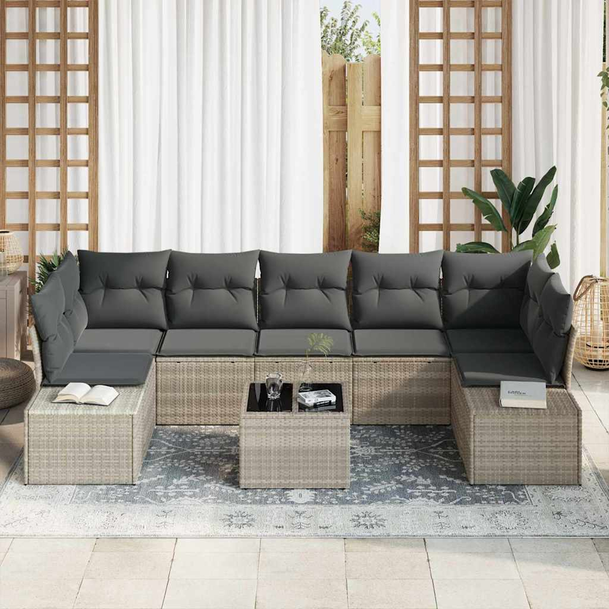 Outdoor-Ecksofa mit grauen Kissen und einem Couchtisch auf einem gemusterten Teppich, in der Nähe eines Fensters.