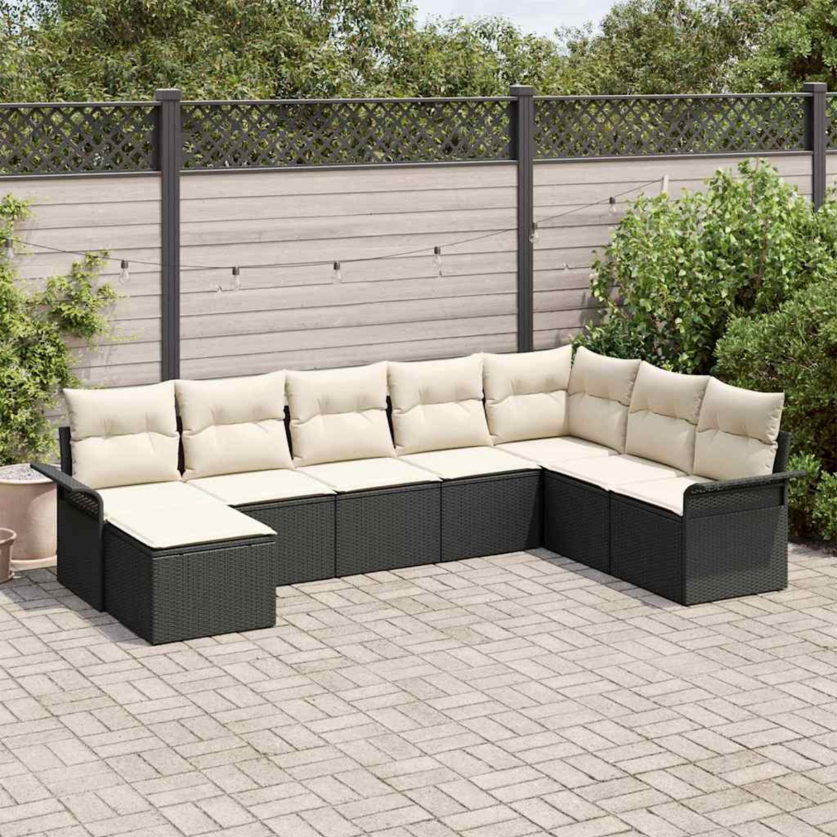 Outdoor-Ecksofa mit cremefarbenen Kissen. Schwarzer Rahmen auf einer Ziegelterrasse, mit Holzzaun und Laub im Hintergrund.