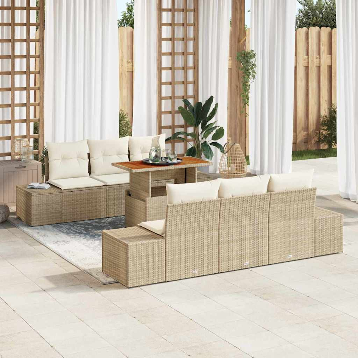Terrassenset im Freien mit Korbmöbeln, weißen Kissen, einem Tisch mit Getränken und weißen Vorhängen im Hintergrund.