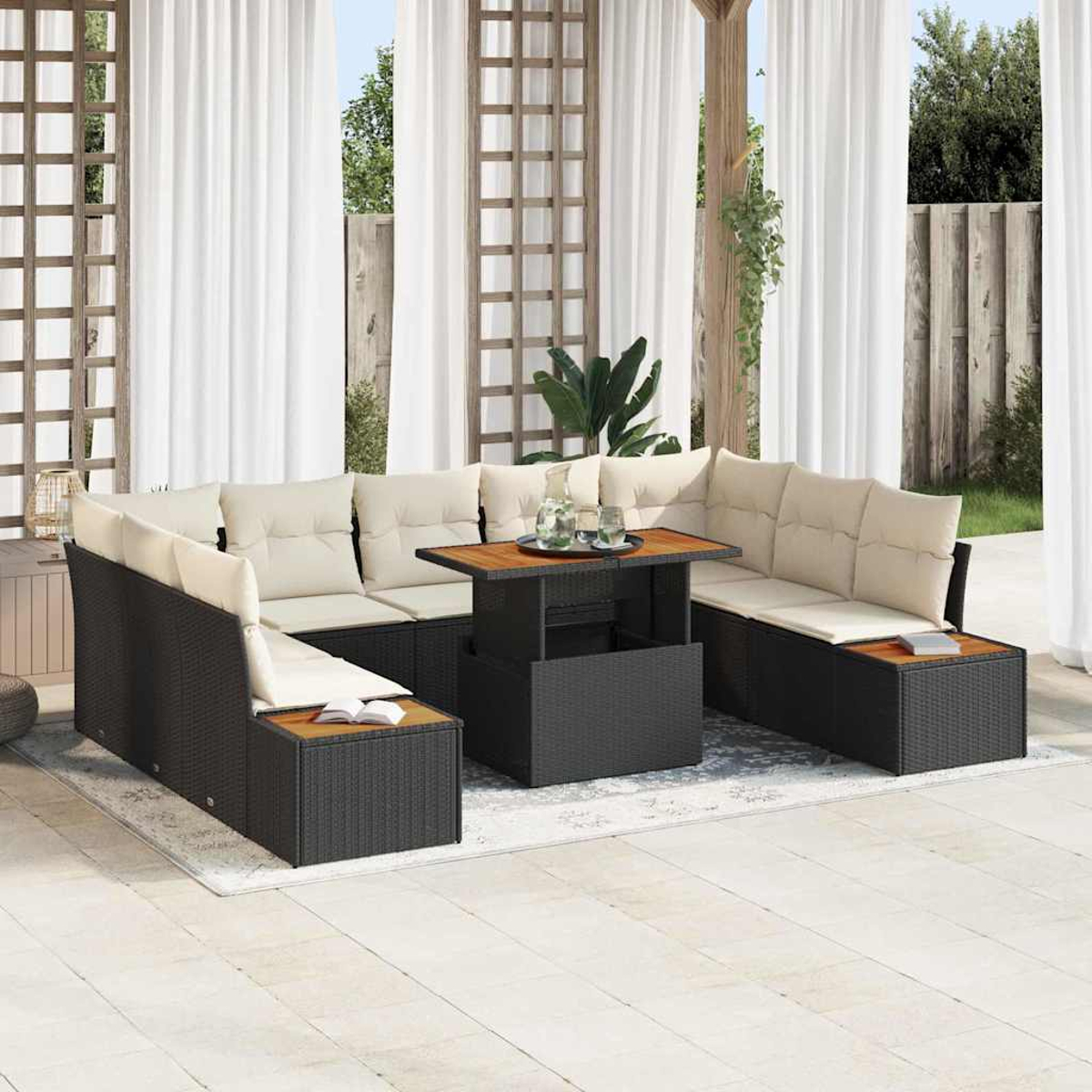 Sofá seccional exterior con cojines beige, estructura de mimbre negro y mesa de madera, sobre un patio. Cortinas blancas al fondo.