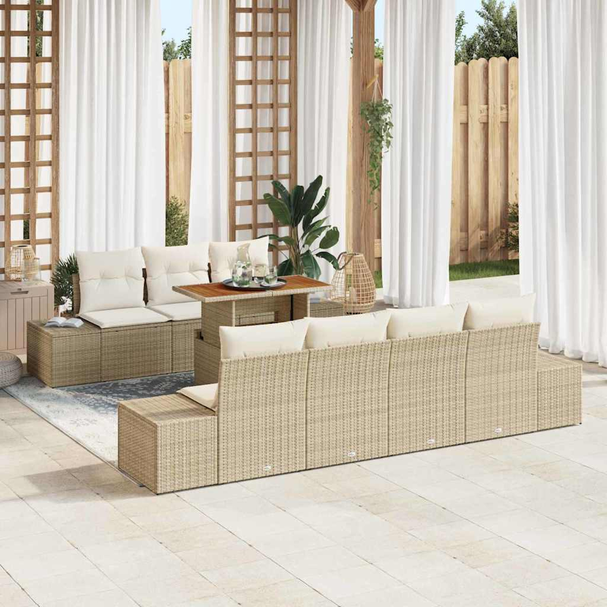 Outdoor-Korbmöbel-Set mit beigen Kissen auf einer Terrasse. Weiße Vorhänge und Holzgitter im Hintergrund. Pflanzen und Tisch.