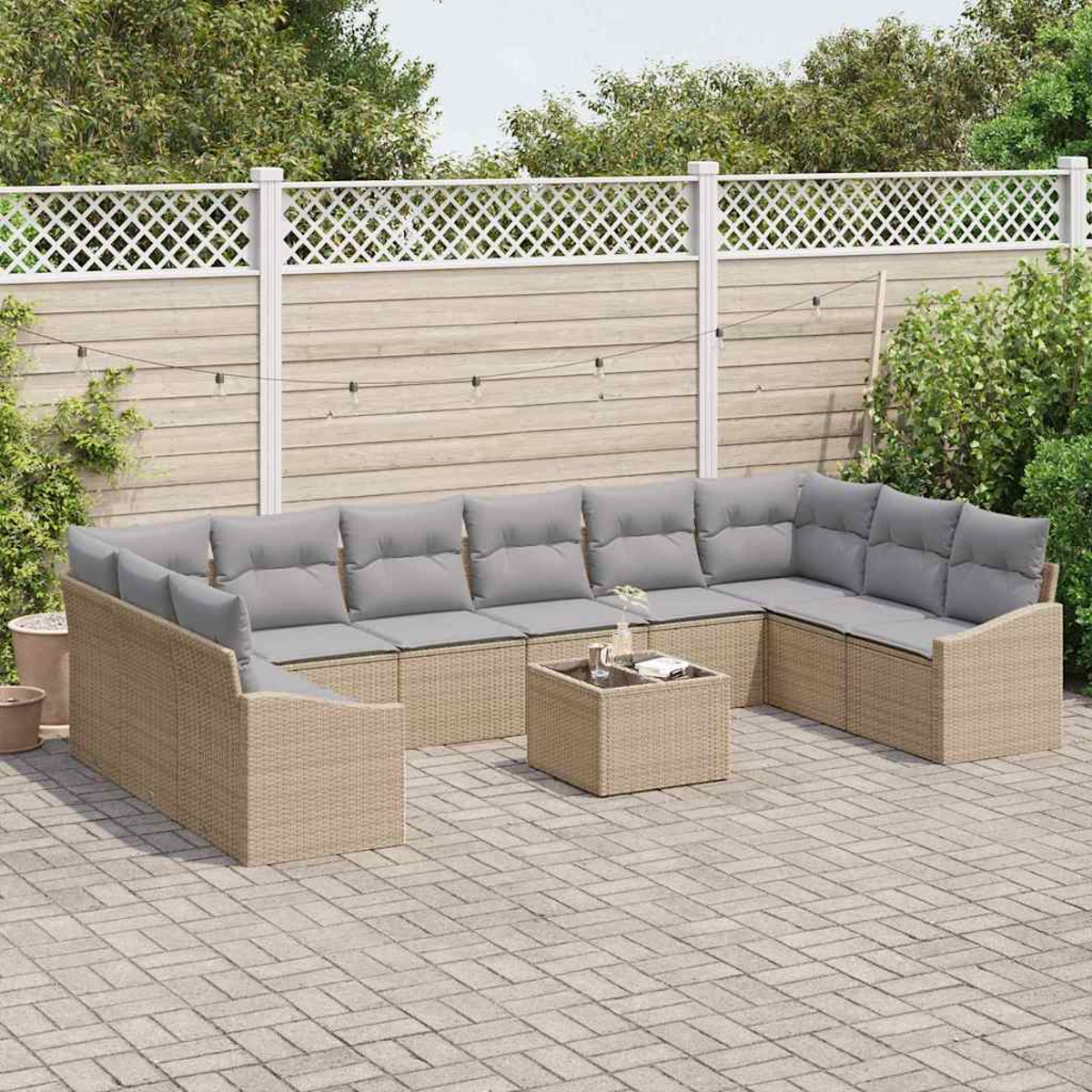 Outdoor-Ecksofa mit grauen Kissen und einem kleinen Tisch auf einer Backstein-Terrasse. Ein weißer Gitterzaun und Grünzeug sind im Hintergrund.