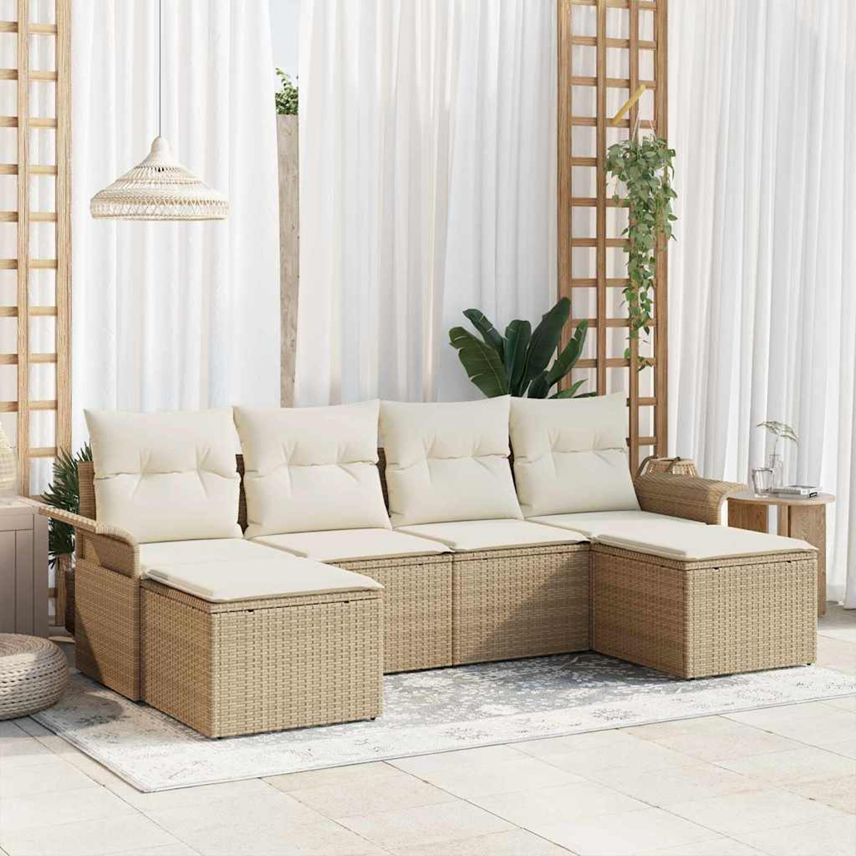 Un sofá seccional de mimbre beige con cojines crema está sobre una alfombra clara. Cortinas blancas y un enrejado de madera de fondo.