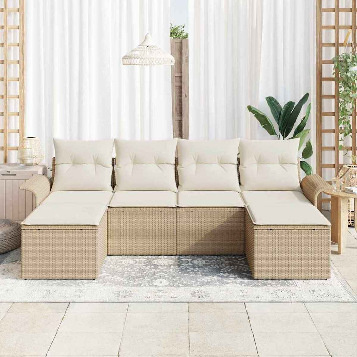 Sofá seccional de mimbre beige con cojines crema en un patio con cortinas blancas, una alfombra y plantas.