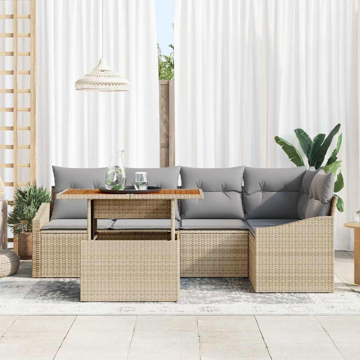 Outdoor-Korbmöbel mit grauen Kissen, ein Holztisch mit Glas und weiße Vorhänge im Hintergrund.