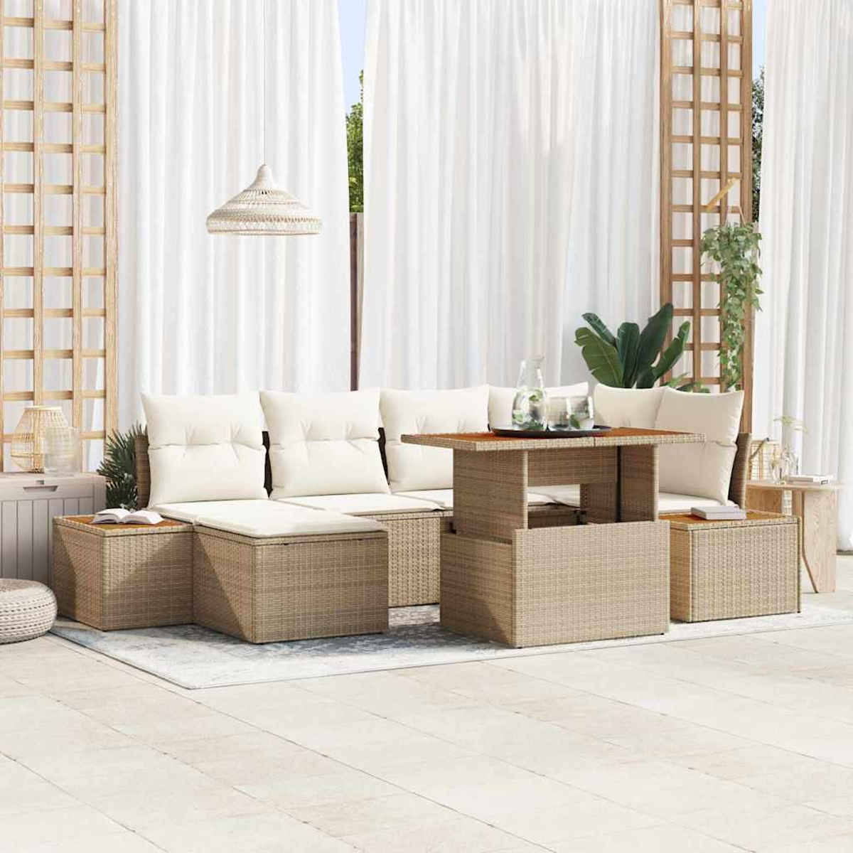 Terrassenset mit beigen Kissen, Tisch und Webmöbeln vor weißen Vorhängen und Holzgitter.