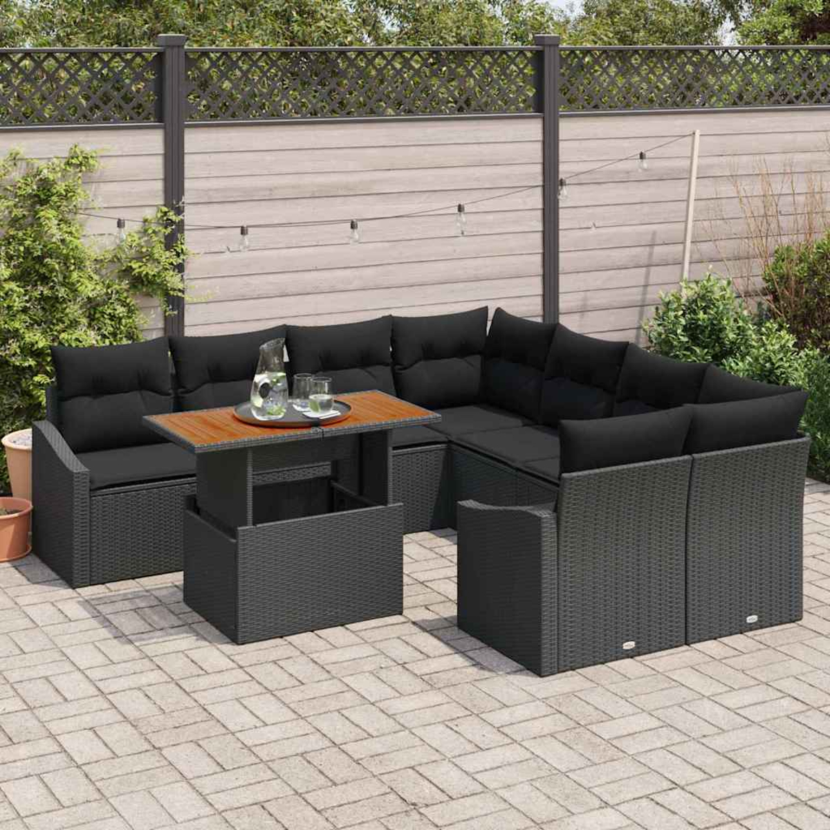 Gartenmöbel-Set: schwarzes Korbsessel-Sofa, Holztisch und dekorativer Zaun in einer Gartenszene.