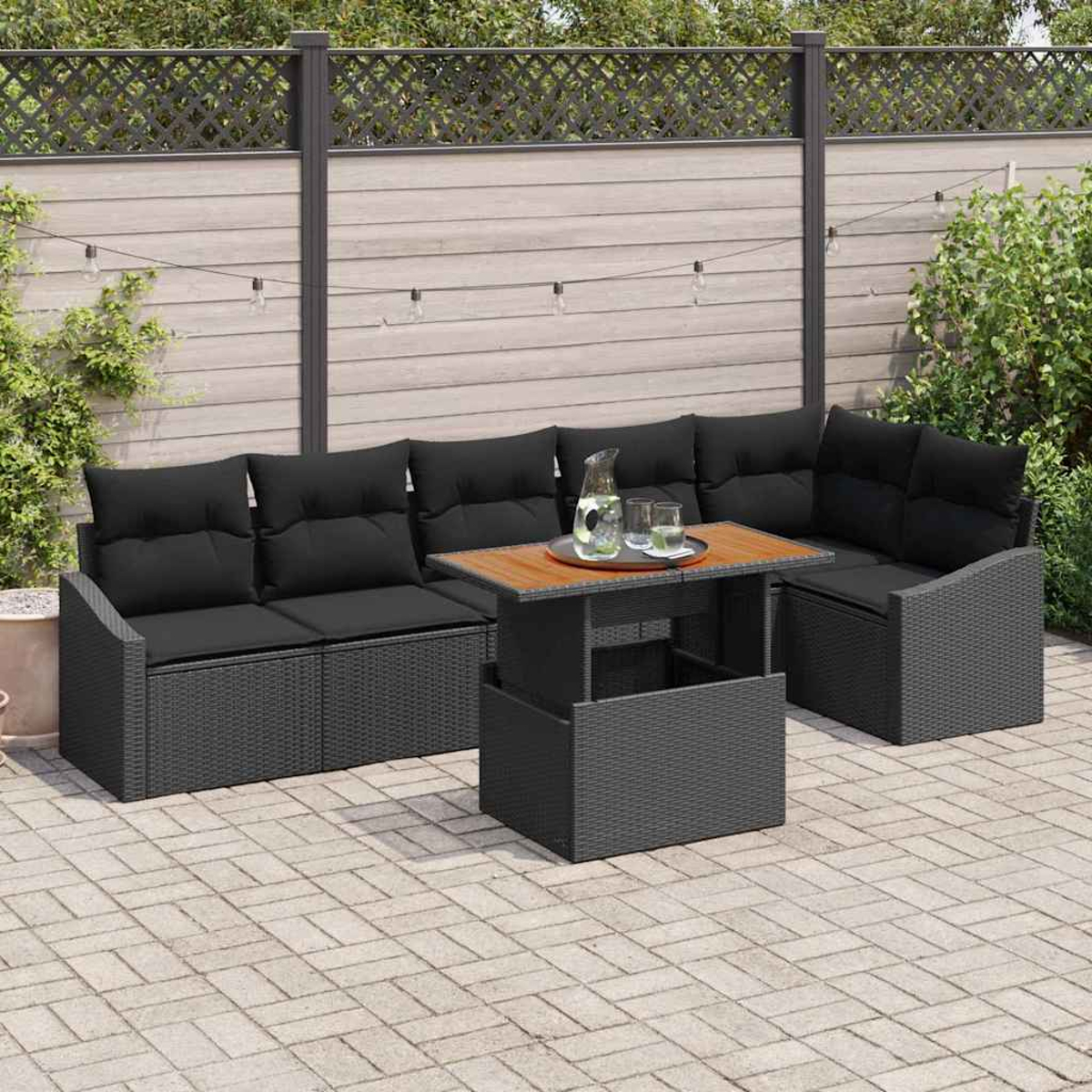 Ein Outdoor-Terrassenset mit schwarzem Sofa, Tisch und Kissen. Auf dem Tisch stehen ein Krug und Gläser.