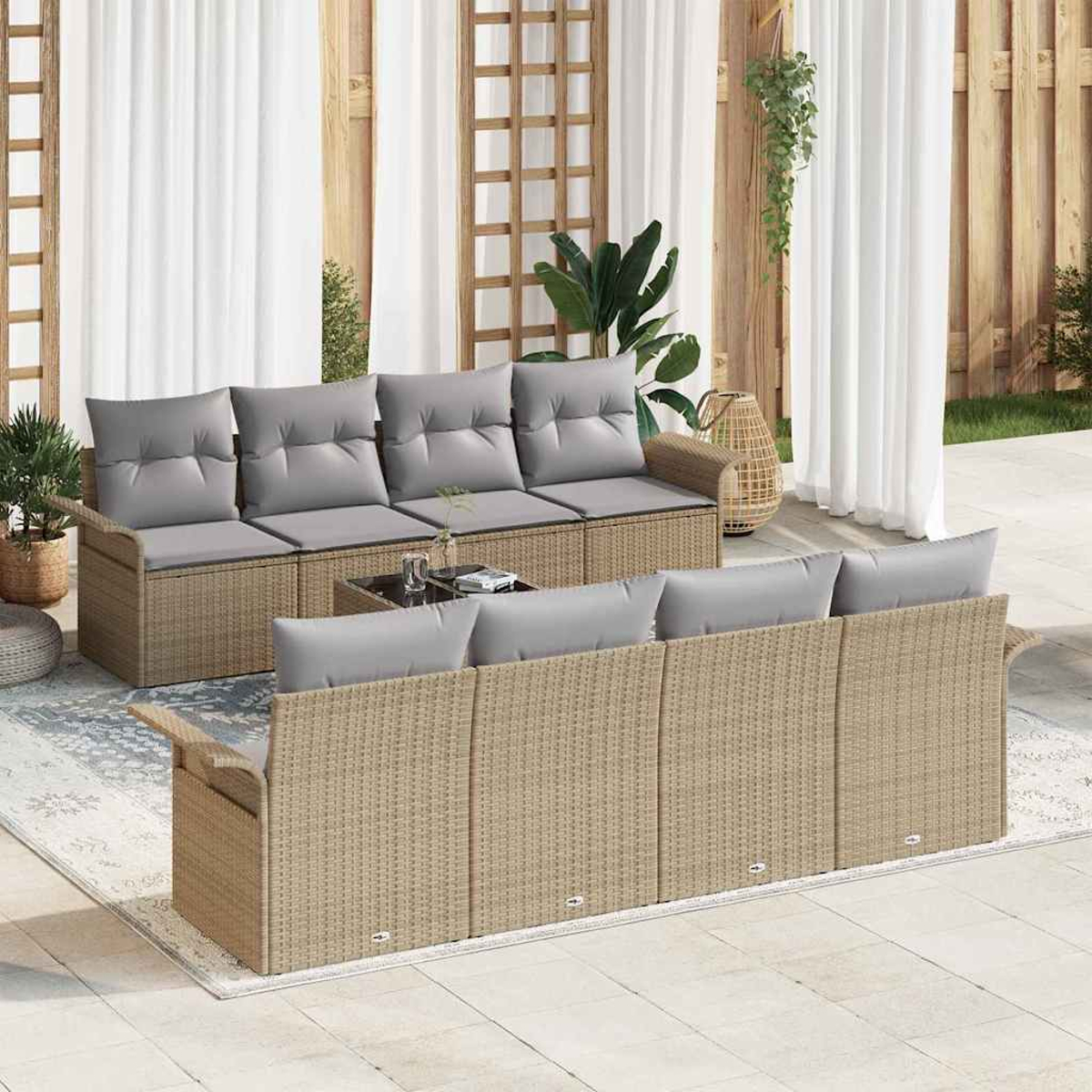 Outdoor-Korbsitzgruppe mit grauen Kissen. Enthält einen Couchtisch. Der Hintergrund hat Vorhänge, Pflanzen und Holzpaneele.