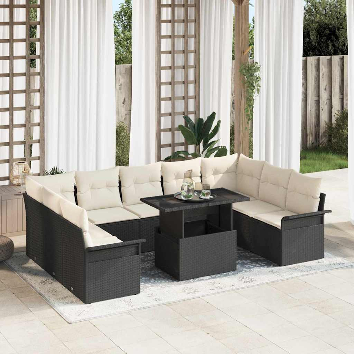 Eine Outdoor-Terrassengarnitur mit schwarzem Korbsitz und cremefarbenen Kissen. Ein dunkler Tisch steht in der Mitte mit Getränken. Weiße Vorhänge im Hintergrund.