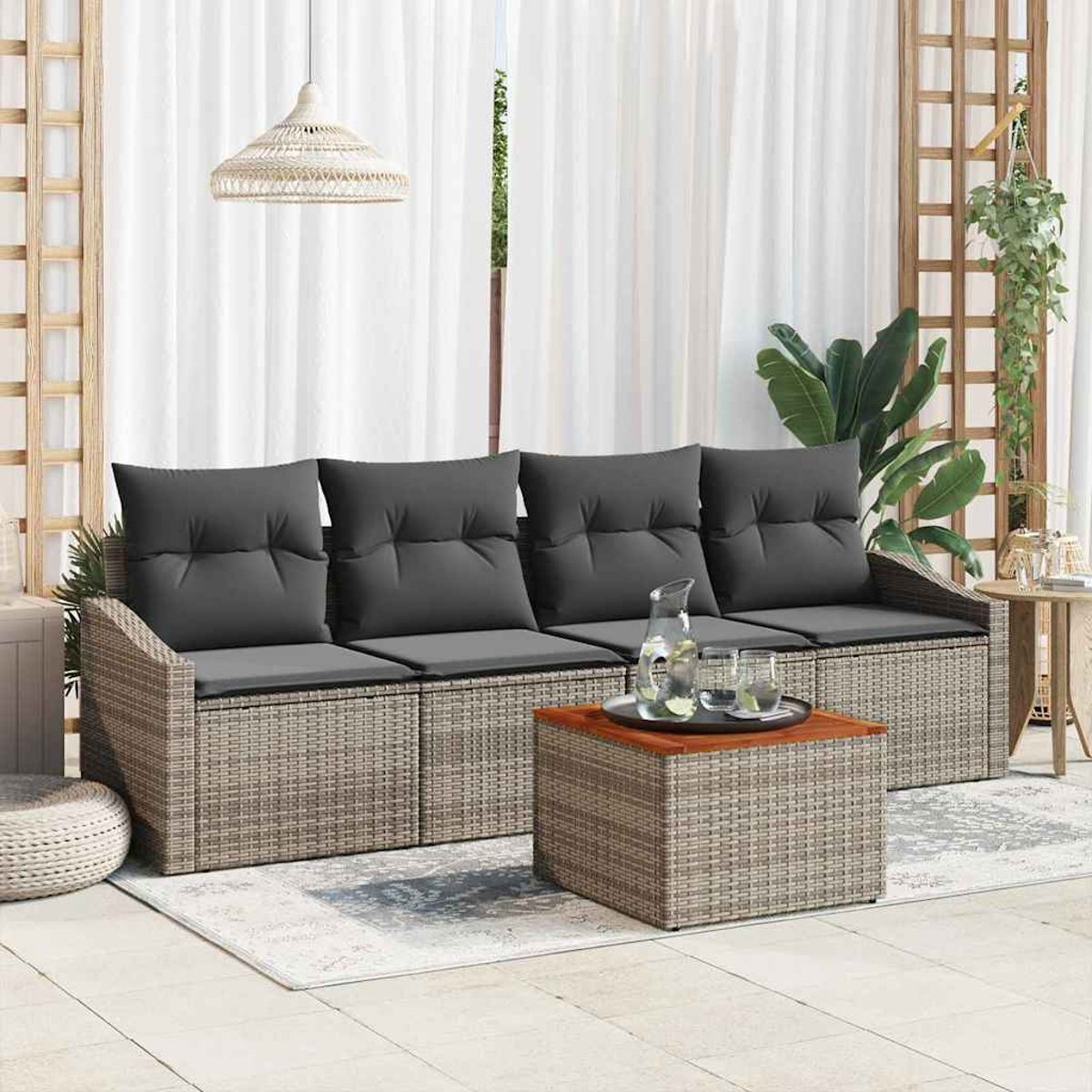 Gartenmöbel-Set mit grauen Kissen. Enthält ein Sofa, einen Couchtisch und einen Beistelltisch. Hintergrund: Vorhänge und Pflanzen.