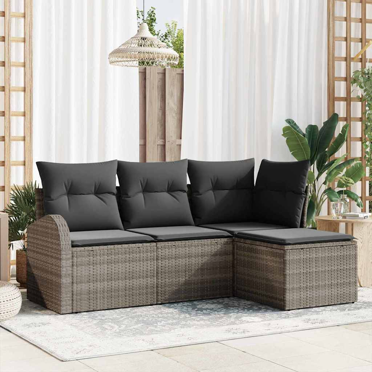 Ein Ecksofa im Freien mit grauen Kissen steht auf einem Teppich. Weiße Vorhänge, Pflanzen und eine gewebte Lampe sind im Hintergrund.
