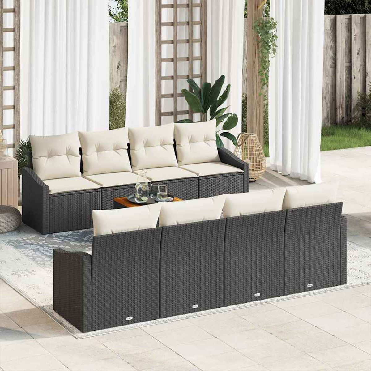 Terrassenmöbel-Set mit dunkelgrauen Korbsesseln und cremefarbenen Kissen. Ein kleiner Tisch mit Gläsern und eine gewebte Lampe sind zu sehen.