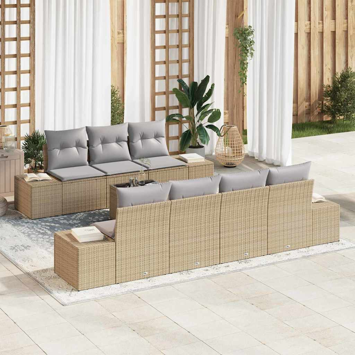 Außenbereich mit beigefarbenen Sofas und grauen Kissen. Weiße Vorhänge und Holzstrukturen bilden den Hintergrund. Pflanzen und ein Teppich sind vorhanden.