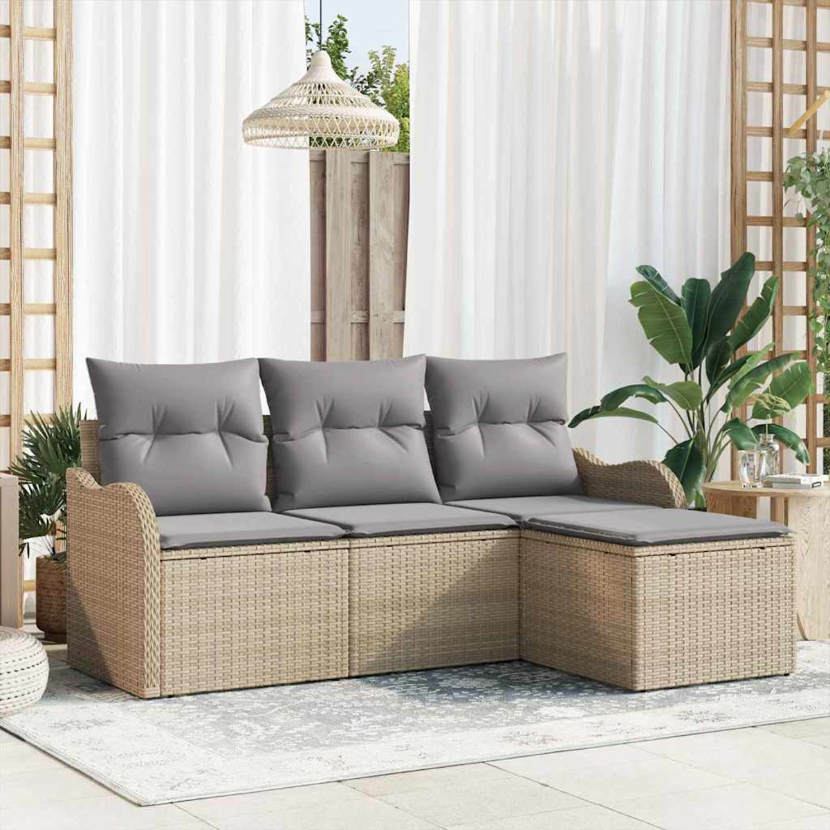 Rattansofa mit grauen Kissen auf einer Terrasse. Weiße Vorhänge und eine Hängelampe sind sichtbar.