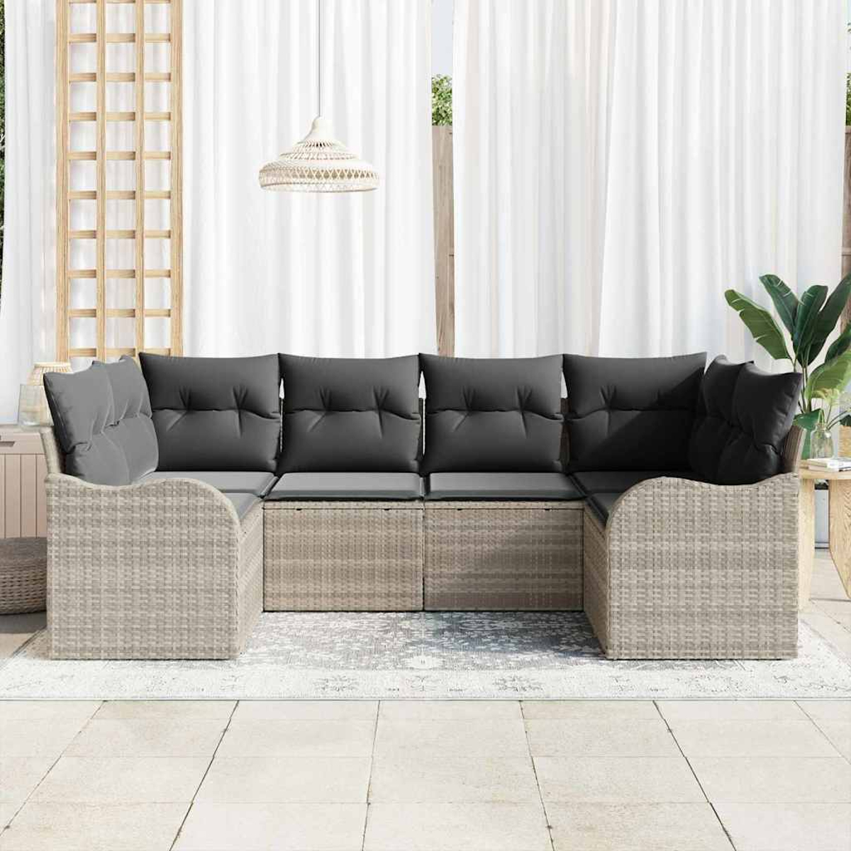 Outdoor-Ecksofa mit grauen Kissen. Es steht auf einem Teppich, im Hintergrund weiße Vorhänge und eine Pflanze.