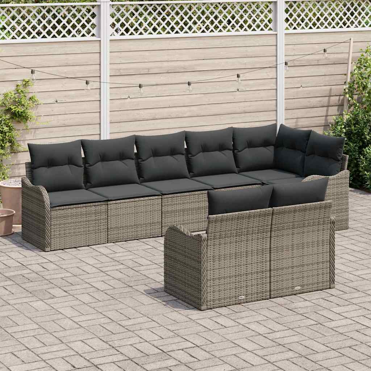Outdoor-Ecksofa mit grauen Kissen auf einer Ziegelterrasse. Im Hintergrund ein weißer Zaun und Lichterketten.