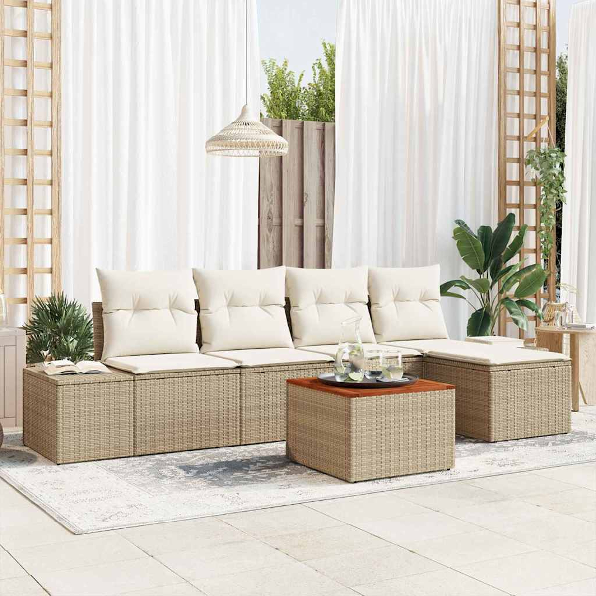 Outdoor-Sitzgruppe mit beigen Kissen, Rattanmöbeln, einem Holztisch, weißen Vorhängen und einer Hängelampe.