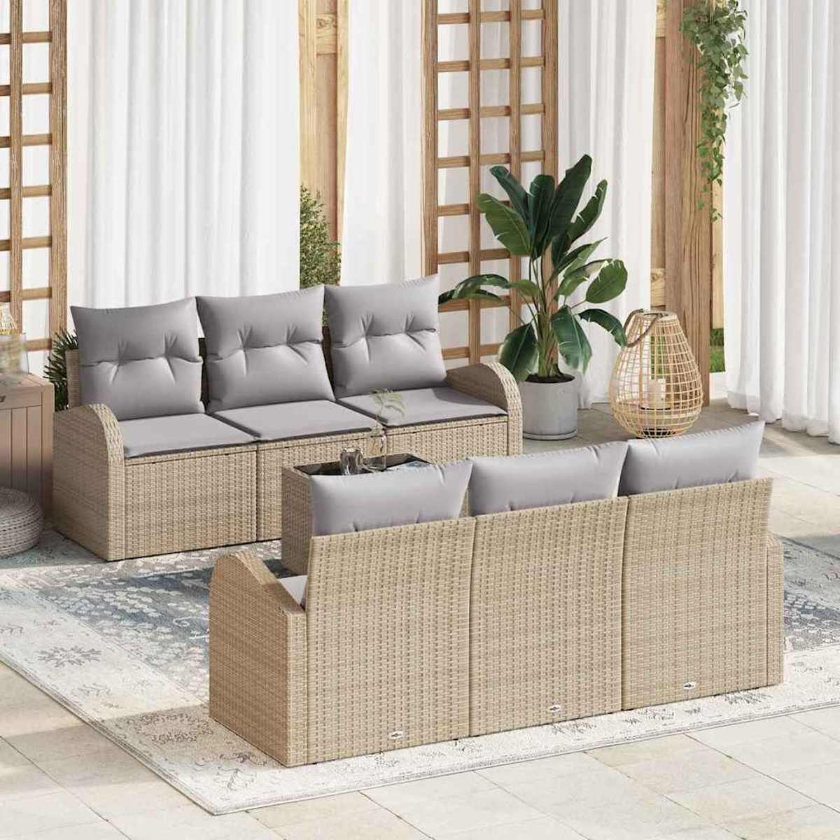 Szene im Freien mit Rattansofas, grauen Kissen, einem Teppich, Pflanzen und einem hölzernen Spalier. Weiße Vorhänge sind im Hintergrund.