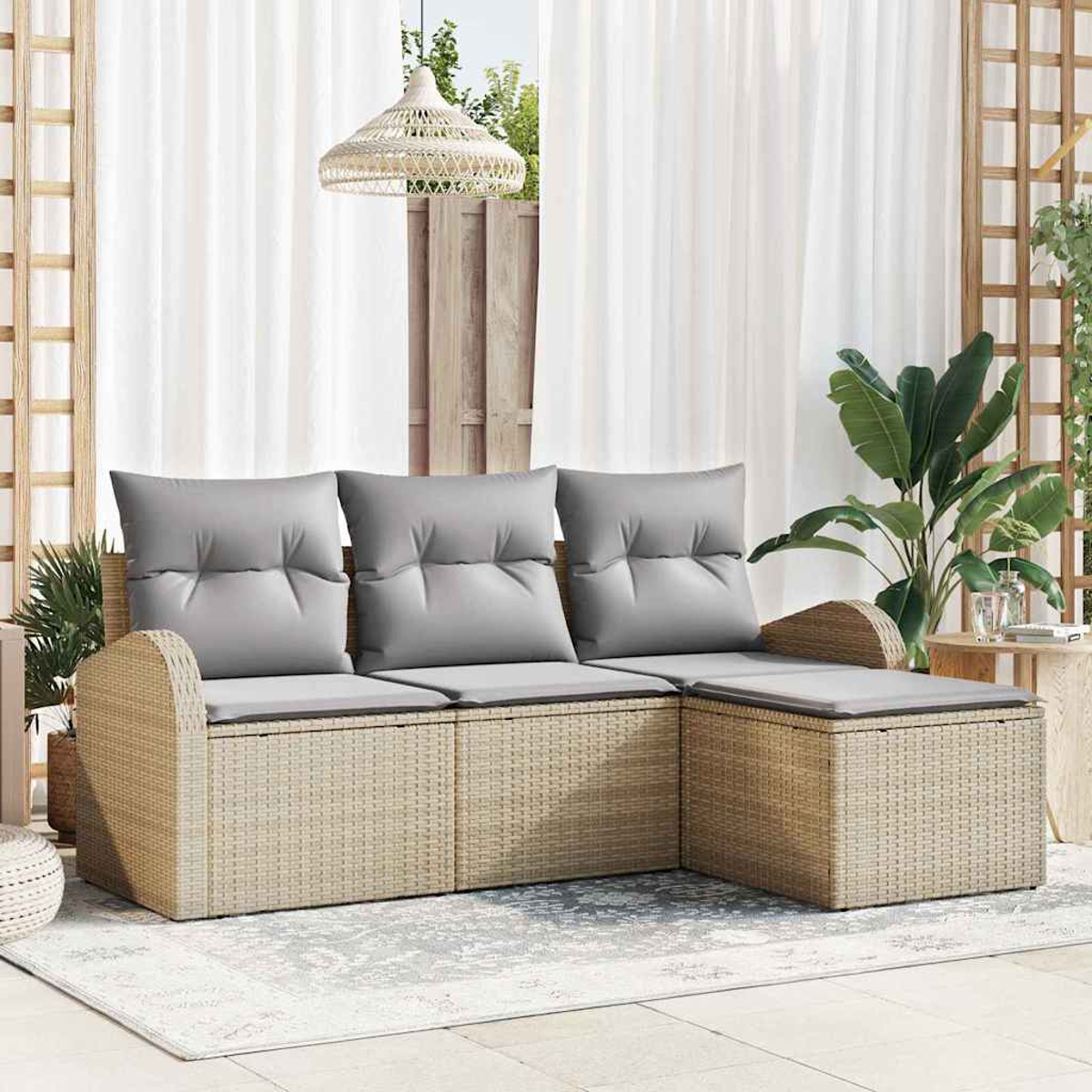 Outdoor-Rattansofa mit grauen Kissen. Weiße Vorhänge, Pflanzen und eine gewebte Lampe im Hintergrund. Auf dem Boden liegt ein Teppich.