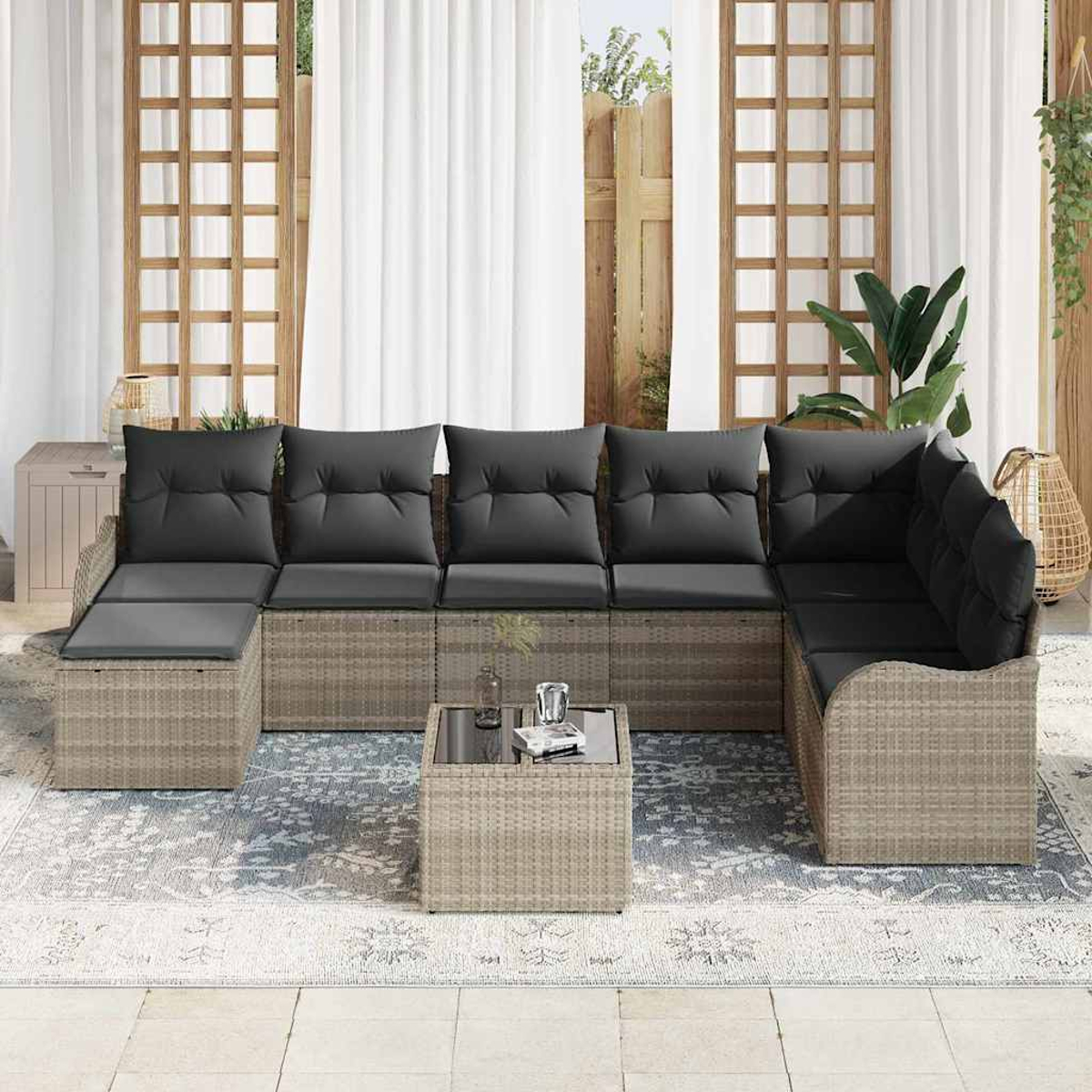 Outdoor-Ecksofa mit grauen Kissen. Davor steht ein kleiner Tisch. Im Hintergrund Vorhänge und Gitterfenster.