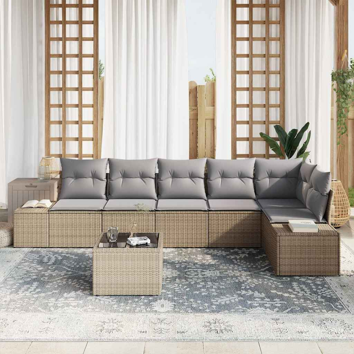 Outdoor-Ecksofa mit grauen Kissen. Ein Couchtisch steht auf einem gemusterten Teppich. Weiße Vorhänge und Holzgitter im Hintergrund.