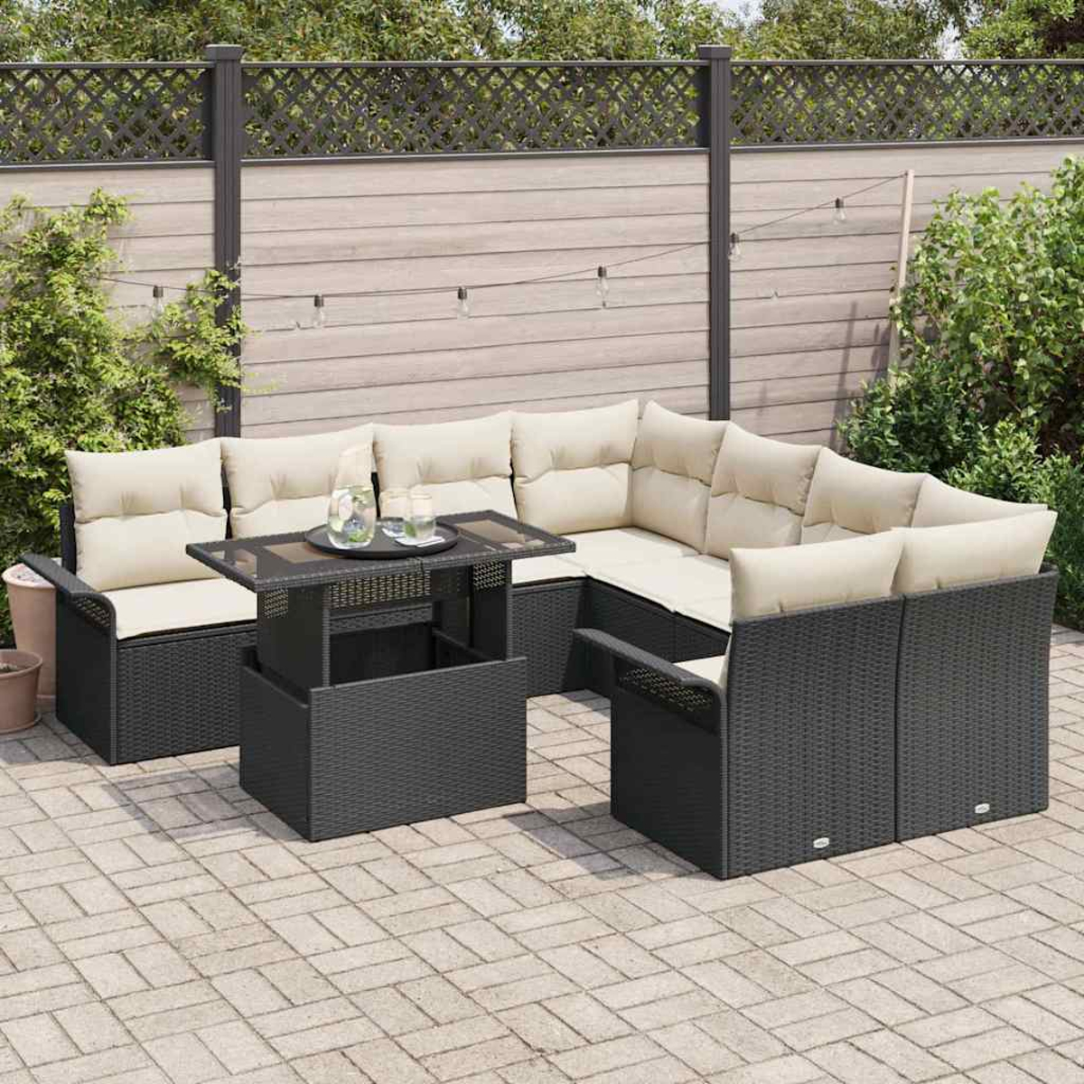 Gartenmöbel-Set mit schwarzem Korbgeflecht und beigen Kissen. Ein Tisch mit Glasplatte und Getränken steht im Zentrum, umgeben von Sitzgelegenheiten.