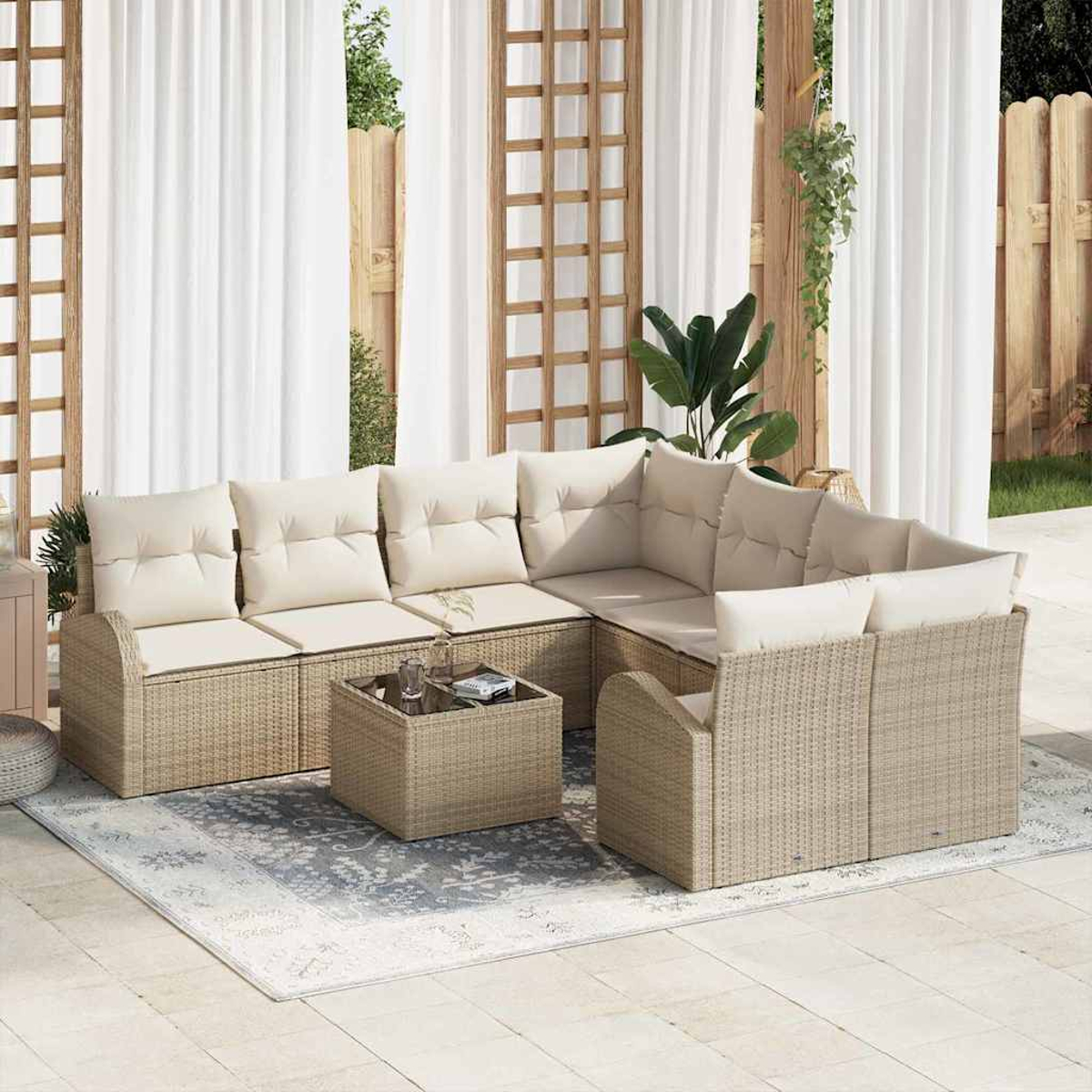 Outdoor-Sitzgruppe mit beigen Kissen. Enthält ein Ecksofa, einen Couchtisch und einen Teppich. Im Hintergrund sind Vorhänge und ein Holzzaun zu sehen.