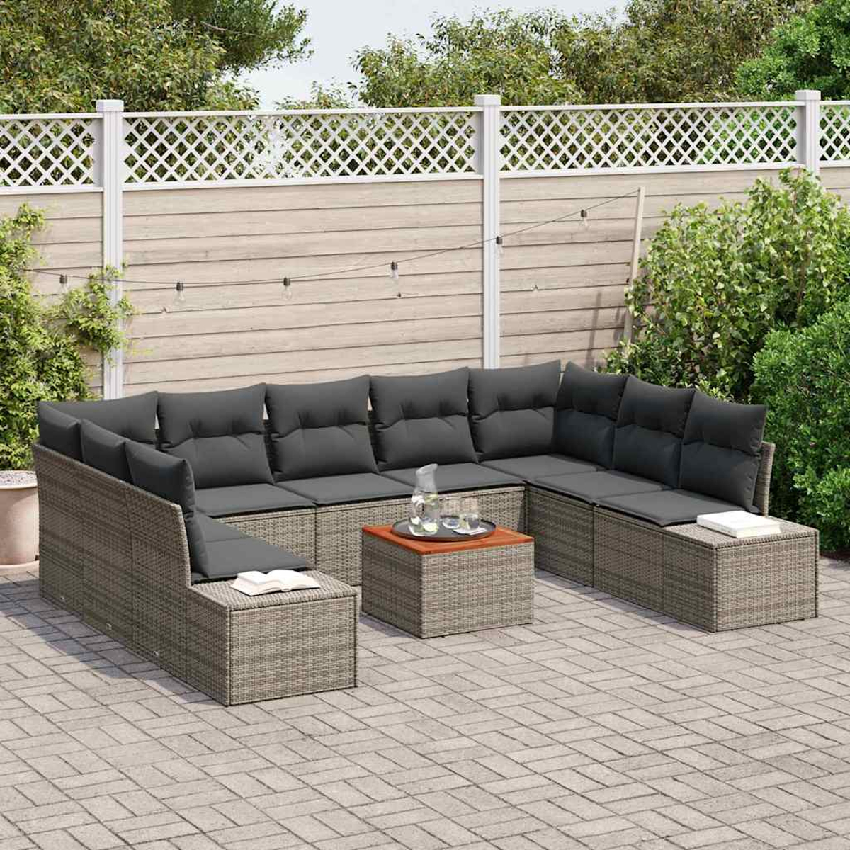Outdoor-Ecksofa mit grauen Kissen und Kissen, einem Couchtisch, auf einer Backstein-Terrasse, mit weißem Zaun und Grün.