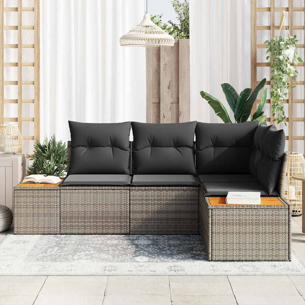 Graues Ecksofa für den Außenbereich mit schwarzen Kissen. Holztisch und gemusterter Teppich. Pflanzen und eine Hängelampe sind ebenfalls sichtbar.