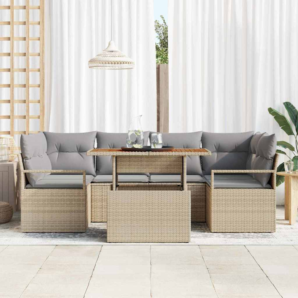 Outdoor-Rattansofa-Set mit grauen Kissen, einem Holztisch und weißen Vorhängen im Hintergrund.