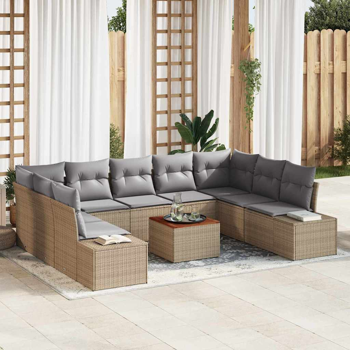 Sofá de mimbre para exteriores con cojines grises, una mesa de centro y cortinas blancas. La escena está en un patio con valla de madera.