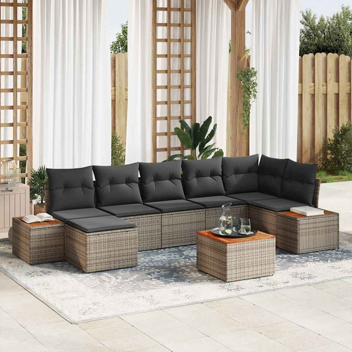 Outdoor-Ecksofa mit grauen Kissen, Couchtisch und Teppich. Weiße Vorhänge und Holzzaun sind im Hintergrund zu sehen.