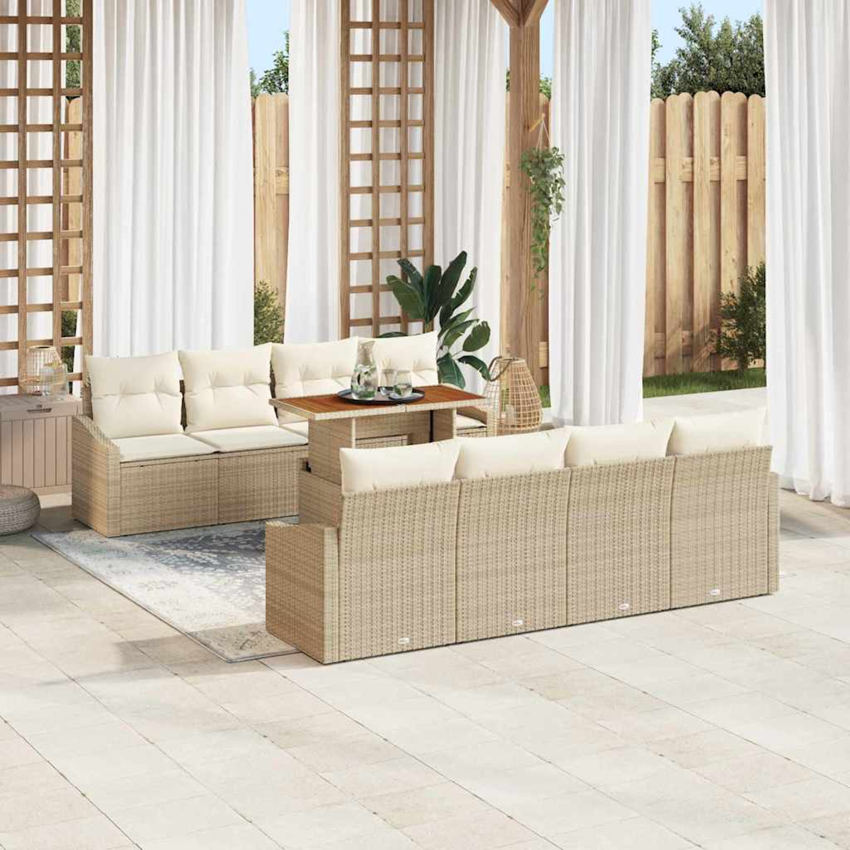 Garten-Terrassenset mit beigen Korbmöbeln, weißen Kissen und Holztisch. Weiße Vorhänge, Holzzaun und dekorative Pflanzen.