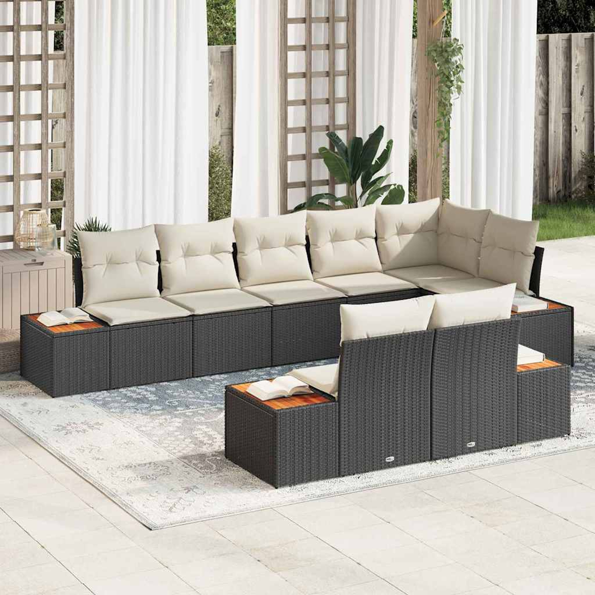 Outdoor-Ecksofa mit beigen Kissen. Der dunkelgraue Rahmen steht auf einem hellen Teppich. Weiße Vorhänge und Pflanzen sind im Hintergrund.