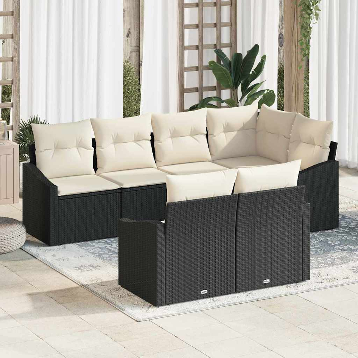 Outdoor-Ecksofa mit cremefarbenen Kissen. Schwarzer Korbrahmen. Beiger Teppich auf einer gefliesten Terrasse. Weiße Vorhänge und Holzgitter im Hintergrund.