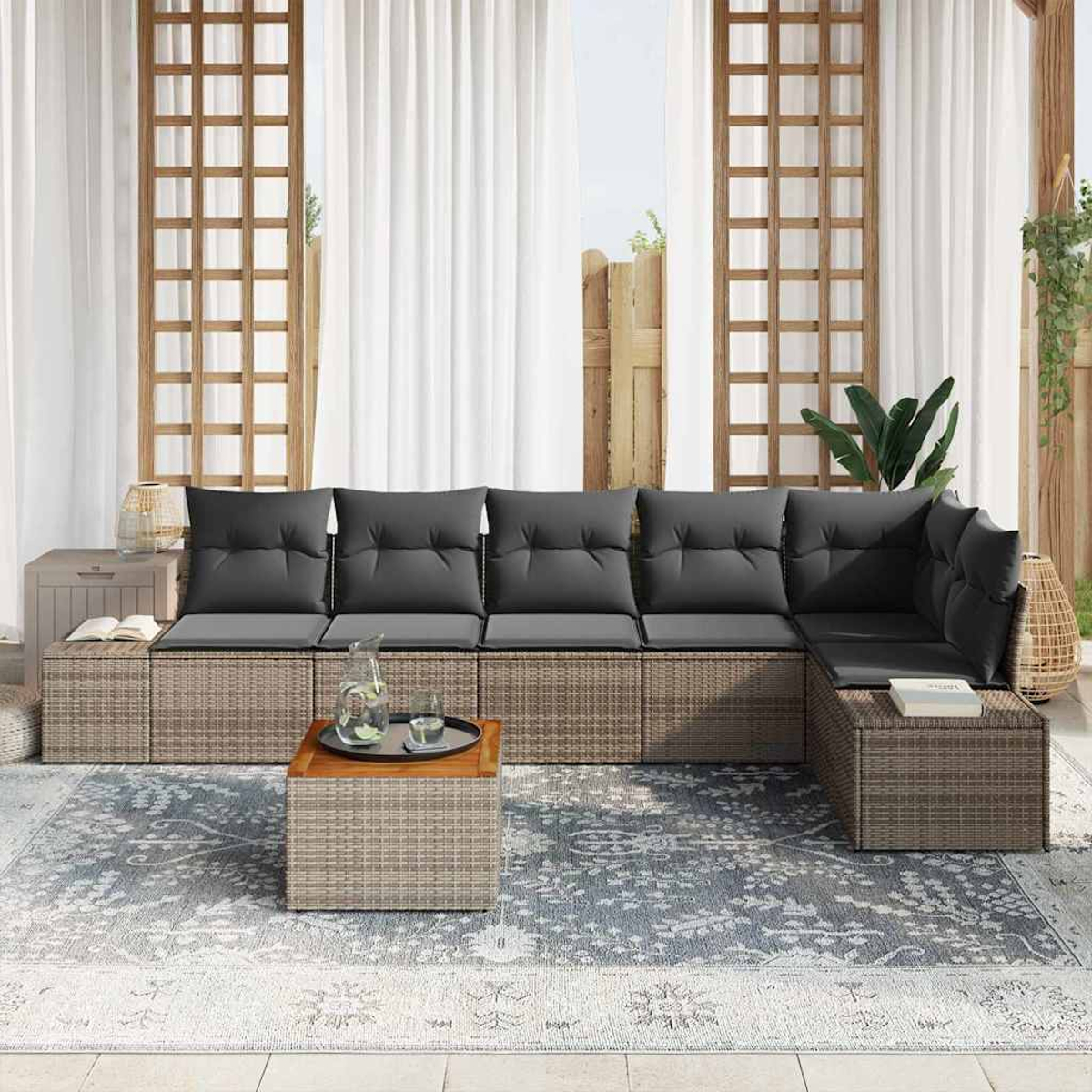 Outdoor-Ecksofa mit grauen Kissen, Holztisch und gemustertem Teppich. Weiße Vorhänge und Holzgitter im Hintergrund.