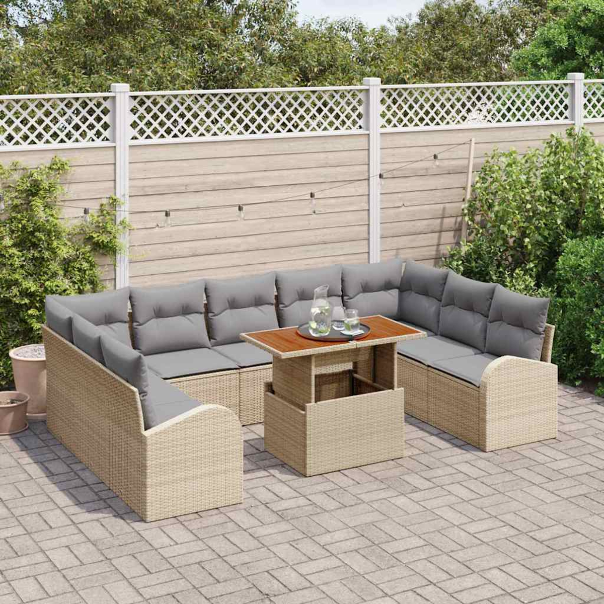 Outdoor-Ecksofa mit grauen Kissen und einem Holztisch. Auf einer gepflasterten Terrasse, vor einem Zaun und Grün.