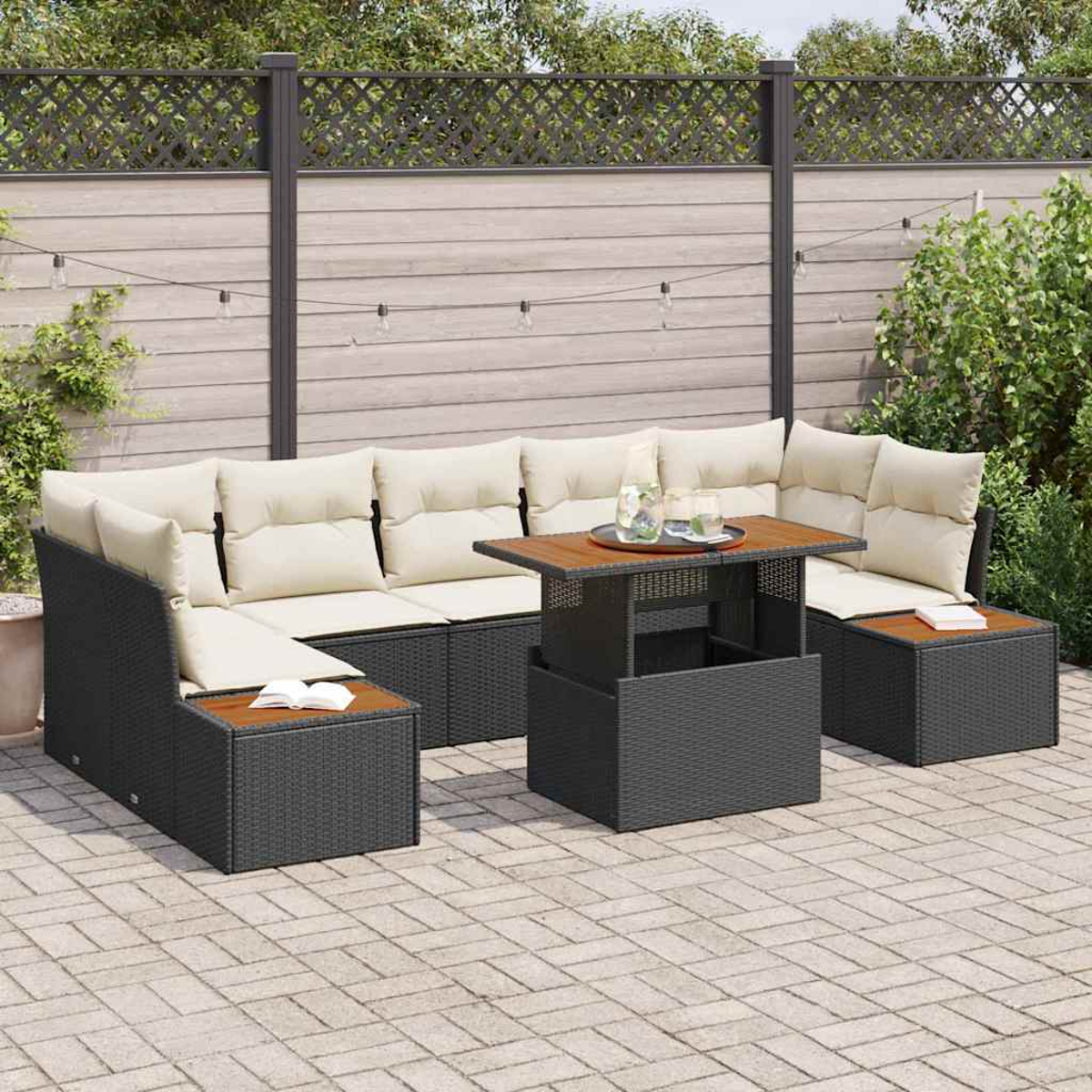 Sofá seccional para exteriores con cojines crema y una mesa de madera. El fondo incluye una valla, plantas y luces de cadena.